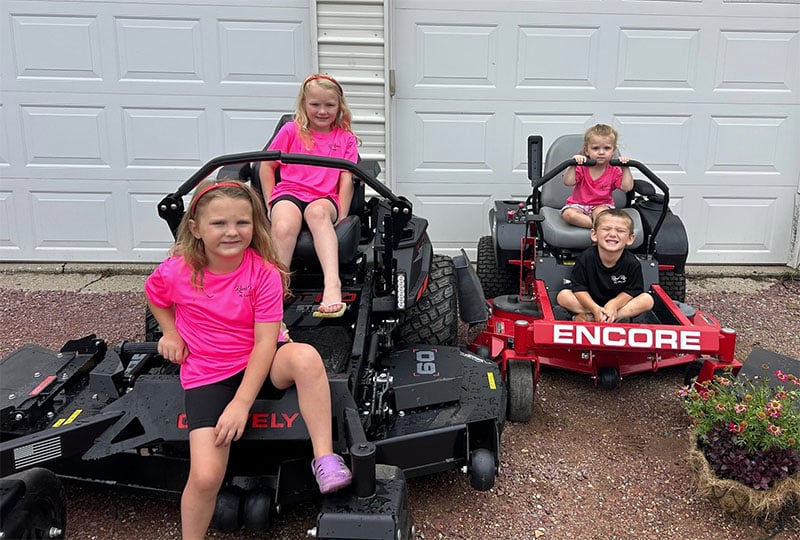 family on riding mowers